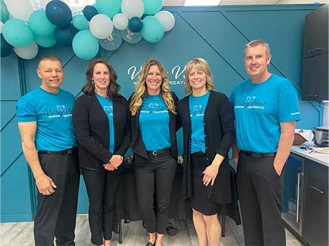 Company staff standing in a row wearing the same blue t-shirt
